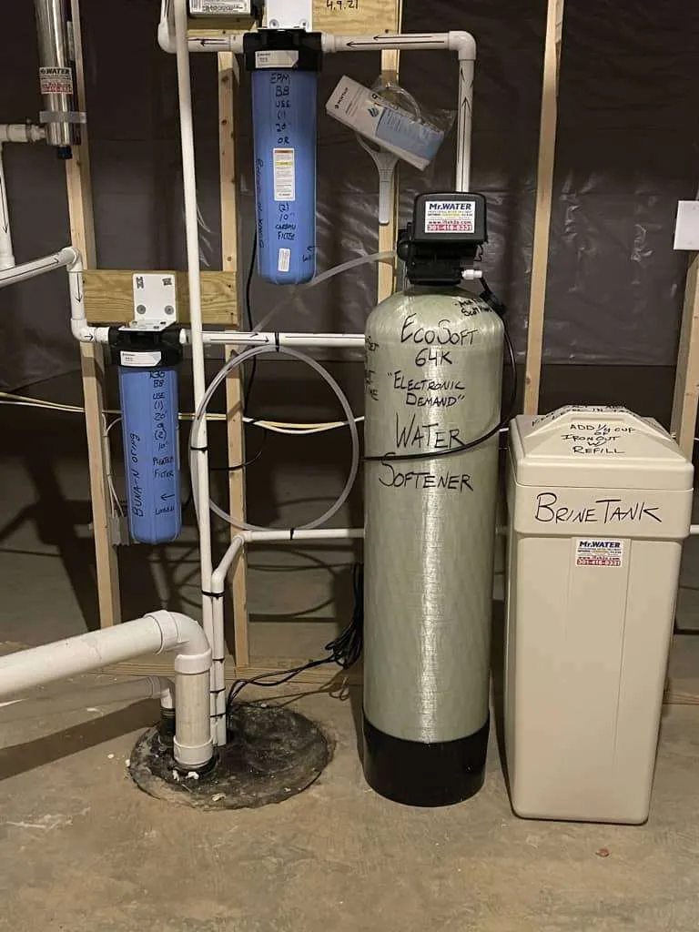 A professional whole house water softener and carbon filtration system installed in a residential utility room